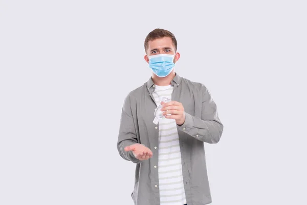 Uomo che utilizza mani antisettiche indossare maschera medica isolato. Disinfettante mani — Foto Stock