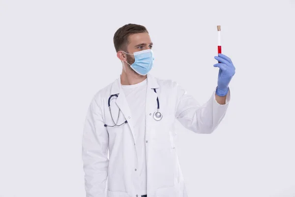 Man Doctor Holding Blood Tube Analysis bär medicinsk mask och handskar. Doktorn undersöker blodprov. Vetenskap, medicinskt koncept. Isolerad. — Stockfoto