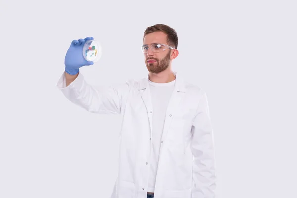 Человек-доктор, осматривающий чашу Петри в изолированных очках. Медицина, наука — стоковое фото