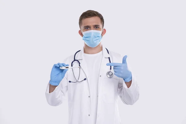 Doctor Showing Thermometer Het dragen van medische masker en handschoenen geïsoleerd. Man Doctor met thermometer in handen wijzend ernaar. Gezond leven, dokter, Virus Concept — Stockfoto