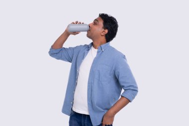 Teneke kutudan bira içen Hintli adam. Ellerinde içki olan Hintli adam izole edildi.