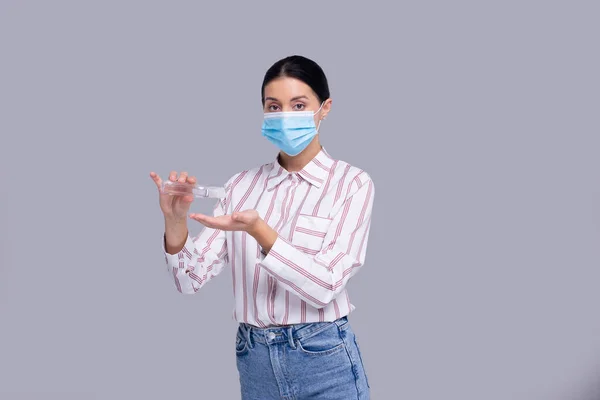 Девушка в медицинской маске изолирована. Девушка, использующая антисептик для рук. Здоровье, медицина, изоляция — стоковое фото