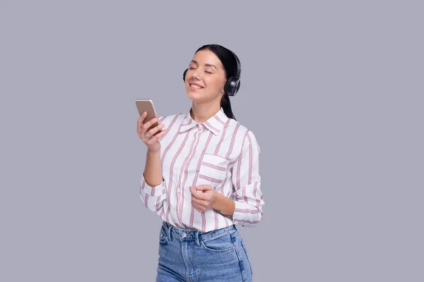 Girl Listening to Music from Phone Enjoying It. Menina Ouvindo Música com fones de ouvido sem fio Isolado — Fotografia de Stock