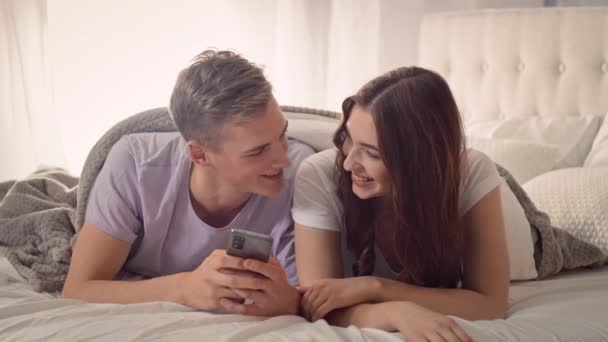夫妻在床上用电话 在床上用电话购物的情侣 网上购物的乐趣 一对夫妇在床上 情人概念 — 图库视频影像
