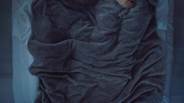 Yatakta uzanmış, gülümseyen ve birbirine bakan bir çift. Çift uyumaya gidiyor..