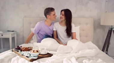 Yatakta kucaklaşan çift. Yatak Sabahı 'ndaki çift. Yatakta Kahvaltı 'da. Sevgi Burunlara Dokunur.