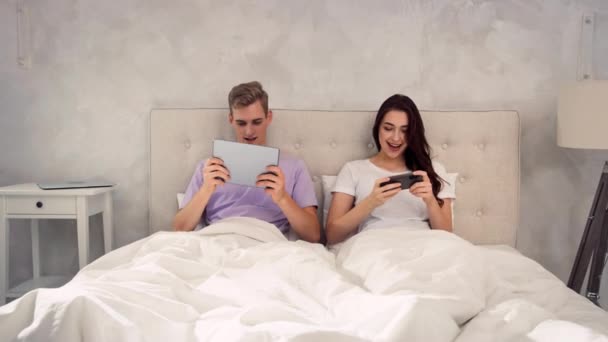 Casal Deitado Cama Com Tablet Telefone Mãos Casal Jogando Jogos — Vídeo de Stock