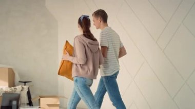 Yeni Evde Yürüyen Genç Bir Çift Son Şeyleri Getiriyorlar. Çift yeni evi tartışıyor. Mutlu çift kanepeye oturup dinleniyor..