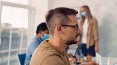 Adam Yaratıcı Ofiste Tıbbi Maske Takıyor. İş yerinde tıbbi koruma. Ofiste tıbbi maske takan adam. Sağlık, Sağlık, Corona Virüsü Konsepti. Evet.
