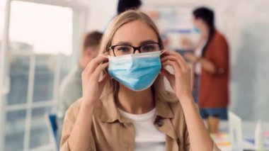 Kız Yaratıcı Ofiste Tıbbi Maske Takıyor. İş yerinde tıbbi koruma. Ofiste tıbbi maske takan bir kadın. Sağlık, Sağlık, Corona Virüsü Konsepti.