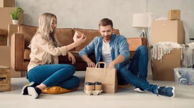 Evde yemek yiyen bir çift. Bir çift New Home 'a taşınmış. Evde Fast Food.