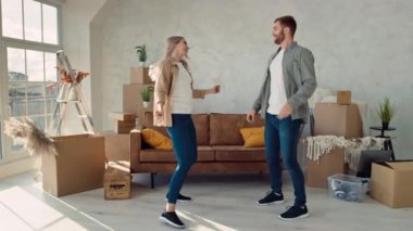 New Home 'da çift dansı. Çift yeni Düz Danslı Mutlu Taşındı. İlk Ev Alışverişini Kutlayan Çift.