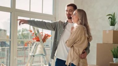 Pencereden dışarı bakan çift yeni Düz Kız Gösteriyor. Çift yeni bir eve taşındı. Çiftler güneşli bir günde taşınıyor.