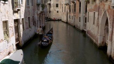 Venice, Italy - september 05, 2021:  Narrow canal with gondola in Venice, Italy. Architecture and landmark of Venice. Cozy cityscape of Venice.