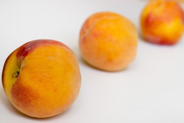 beyaz zemin üzerinde üç şeftali