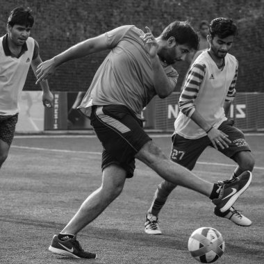 New Delhi, India - July 01 2018: Footballers of local football team during game in regional Derby championship on football pitch. Hot moment of football match on grass field stadium - Black and White