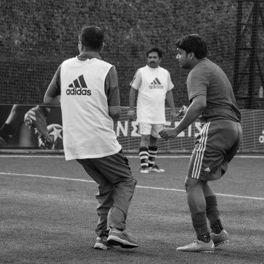 New Delhi, India - July 01 2018- Footballers of local football team during game in regional Derby championship on football pitch. Hot moment of football match on grass field stadium - Black and White