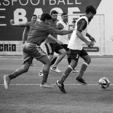 New Delhi, India - July 01 2018- Footballers of local football team during game in regional Derby championship on football pitch. Hot moment of football match on grass field stadium - Black and White