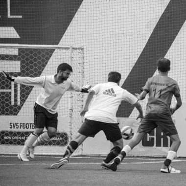 Yeni Delhi, Hindistan - 01 Temmuz 2018 - Yerel futbol takımının futbol sahasında oynanan bölgesel Derby şampiyonası sırasında futbolcuları. Çim sahası stadyumunda futbol maçının sıcak anı - Siyah ve Beyaz