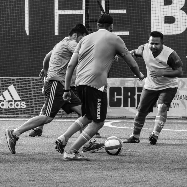New Delhi, India - July 01 2018- Footballers of local football team during game in regional Derby championship on football pitch. Hot moment of football match on grass field stadium - Black and White