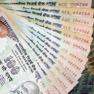 Masada birleşik 100 rupi, dönen masada Hindistan parası var. Eski Hint Para Birimi notları masanın üzerinde, Hint Para Birimi masanın üstünde.
