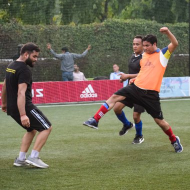 Yeni Delhi, Hindistan - Temmuz 01 2018 - Kötü bir futbol sahasında bölgesel Derby şampiyonasında yerel futbol takımının futbolcuları. Stadyumun çimen yeşili sahasında sıcak bir futbol maçı var.