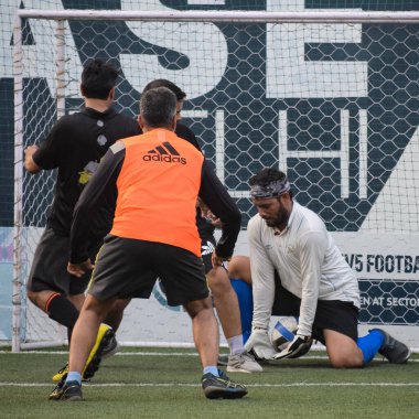 Yeni Delhi, Hindistan - Temmuz 01 2018 - Kötü bir futbol sahasında bölgesel Derby şampiyonasında yerel futbol takımının futbolcuları. Stadyumun çimen yeşili sahasında sıcak bir futbol maçı var.