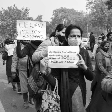 Delhi, Hindistan 25 Aralık 2021 - Delhi Sözleşmeli Konuk Öğretmenler Delhi AAP Hükümetini politika yaptıkları için protesto eden posterler, bayraklar ve graffitilerle, Delhi Öğretmeni Siyah ve Beyaz 'ı protesto etti