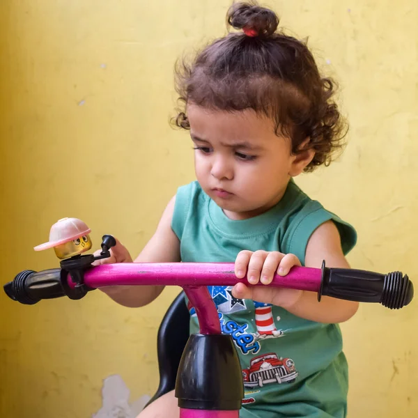 Şirin küçük çocuk Shivaay yaz zamanı balkonda bisiklet sürüyor, gün ışığında tatlı küçük çocuk fotoğraf çekiyor, küçük çocuk fotoğraf çekimi sırasında bisiklet sürmekten hoşlanıyor.