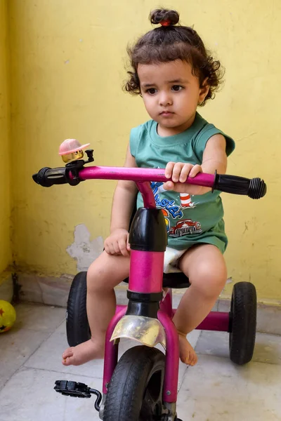 Şirin küçük çocuk Shivaay yaz zamanı balkonda bisiklet sürüyor, gün ışığında tatlı küçük çocuk fotoğraf çekiyor, küçük çocuk fotoğraf çekimi sırasında bisiklet sürmekten hoşlanıyor.