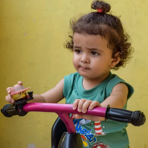 Şirin küçük çocuk Shivaay yaz zamanı balkonda bisiklet sürüyor, gün ışığında tatlı küçük çocuk fotoğraf çekiyor, küçük çocuk fotoğraf çekimi sırasında bisiklet sürmekten hoşlanıyor.