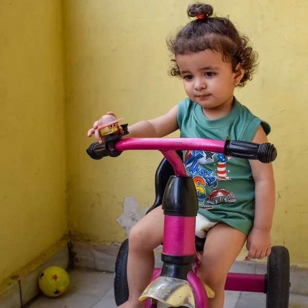Şirin küçük çocuk Shivaay yaz zamanı balkonda bisiklet sürüyor, gün ışığında tatlı küçük çocuk fotoğraf çekiyor, küçük çocuk fotoğraf çekimi sırasında bisiklet sürmekten hoşlanıyor.