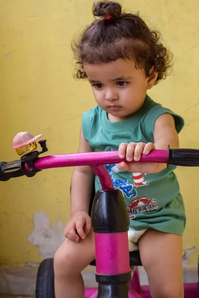 Şirin küçük çocuk Shivaay yaz zamanı balkonda bisiklet sürüyor, gün ışığında tatlı küçük çocuk fotoğraf çekiyor, küçük çocuk fotoğraf çekimi sırasında bisiklet sürmekten hoşlanıyor.