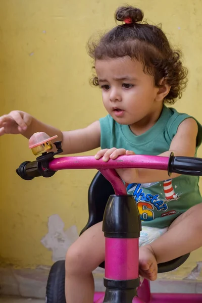 Şirin küçük çocuk Shivaay yaz zamanı balkonda bisiklet sürüyor, gün ışığında tatlı küçük çocuk fotoğraf çekiyor, küçük çocuk fotoğraf çekimi sırasında bisiklet sürmekten hoşlanıyor.