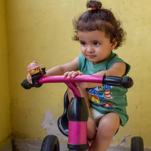 Şirin küçük çocuk Shivaay yaz zamanı balkonda bisiklet sürüyor, gün ışığında tatlı küçük çocuk fotoğraf çekiyor, küçük çocuk fotoğraf çekimi sırasında bisiklet sürmekten hoşlanıyor.