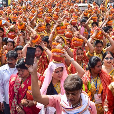 Yeni Delhi, Hindistan 3 Nisan 2022 - Jagannath Tapınağı sırasında Kalaşlı kadınlar Mangal Kalash Yatra, Hintli Hintli dindarlar üzerinde hindistan cevizi olan kutsal su dolu toprak kapları taşıyorlar