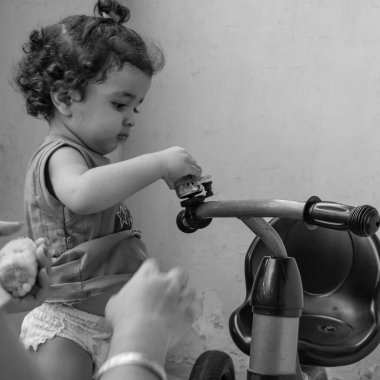 Şirin küçük çocuk Shivaay yaz zamanı balkonda bisiklet sürüyor, gün ışığında tatlı küçük çocuk fotoşopunu çekiyor, küçük çocuk fotoğraf çekimi sırasında evde bisiklet sürmekten hoşlanıyor.