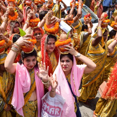 Yeni Delhi, Hindistan 3 Nisan 2022 - Jagannath Tapınağı sırasında Kalaşlı kadınlar Mangal Kalash Yatra, Hintli Hintli dindarlar üzerinde hindistan cevizi olan kutsal su dolu toprak kapları taşıyorlar