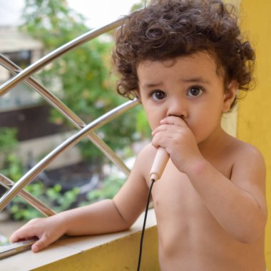 Şirin küçük çocuk Shivaay yaz zamanı evde balkonda, tatlı küçük çocuk gün ışığında fotoşop, küçük çocuk fotoğraf çekimi sırasında evde eğleniyor.