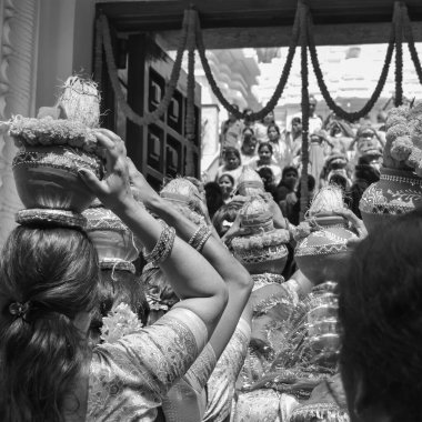 Women with Kalash on head during Jagannath Temple Mangal Kalash Yatra, Indian Hindu devotees carry earthen pots containing sacred water with coconut on top Black and White