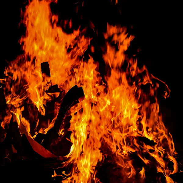 Siyah arka planda alevler, alev alev dokusu arka planda, çok güzel, ateş yanıyor, ateş odun ve inek gübresi ateşiyle yanıyor.