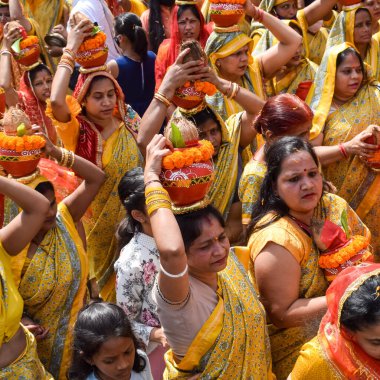 Yeni Delhi, Hindistan 3 Nisan 2022 - Jagannath Tapınağı sırasında Kalaşlı kadınlar Mangal Kalash Yatra, Hintli Hintli dindarlar üzerinde hindistan cevizi olan kutsal su dolu toprak kapları taşıyorlar