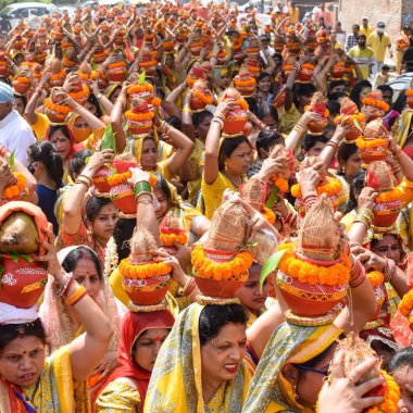 Yeni Delhi, Hindistan 3 Nisan 2022 - Jagannath Tapınağı sırasında Kalaşlı kadınlar Mangal Kalash Yatra, Hintli Hintli dindarlar üzerinde hindistan cevizi olan kutsal su dolu toprak kapları taşıyorlar