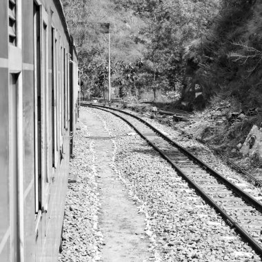 Oyuncak tren dağ yamacında, güzel bir manzara, bir dağ, bir vadi yeşil doğal ormanların arasında, tepeye giden demiryolu üzerinde hareket ediyor. Oyuncak tren Kalka 'dan Shimla' ya Hindistan-Siyah ve Beyaz