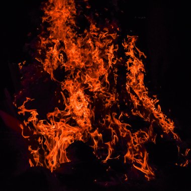 Siyah arka planda alevler, alev alev dokusu arka planda, çok güzel, ateş yanıyor, ateş odun ve inek gübresi ateşiyle yanıyor.