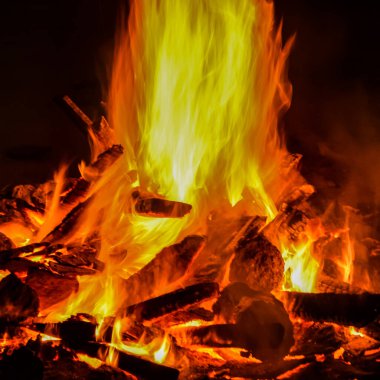 Siyah arka planda alevler, alev alev dokusu arka planda, çok güzel, ateş yanıyor, ateş odun ve inek gübresi ateşiyle yanıyor.