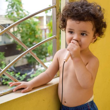 Şirin küçük çocuk Shivaay yaz zamanı evde balkonda, tatlı küçük çocuk gün ışığında fotoşop, küçük çocuk fotoğraf çekimi sırasında evde eğleniyor.