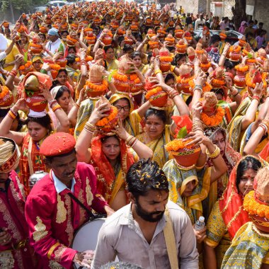 Yeni Delhi, Hindistan 3 Nisan 2022 - Jagannath Tapınağı sırasında Kalaşlı kadınlar Mangal Kalash Yatra, Hintli Hintli dindarlar üzerinde hindistan cevizi olan kutsal su dolu toprak kapları taşıyorlar