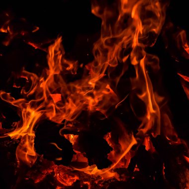 Siyah arka planda alevler, alev alev dokusu arka planda, çok güzel, ateş yanıyor, ateş odun ve inek gübresi ateşiyle yanıyor.