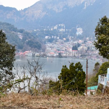 Akşam vakti Nainital, Uttarakhand, Hindistan 'daki Mall Yolu' nun yanındaki Naini Gölü 'nün manzarası dağlarla ve mavi gökyüzüyle güzel Nainital Gölü manzarası.